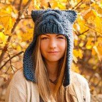 Вязаная шапка с ушками серо-голубого оттенка, выполненная при помощи крупной вязки косички.